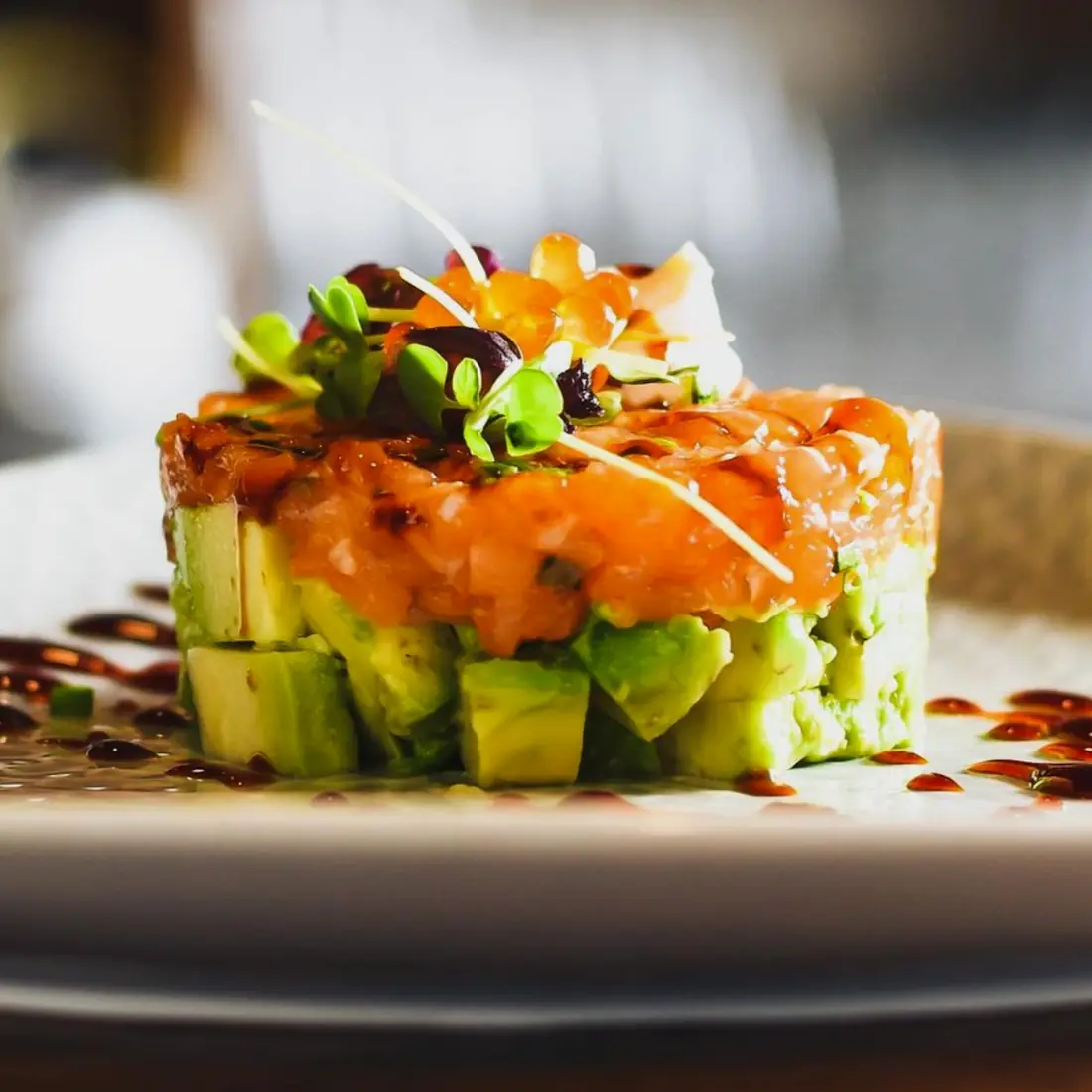 Lachstatar auf Avocadowürfeln, mit Kresse angerichtet