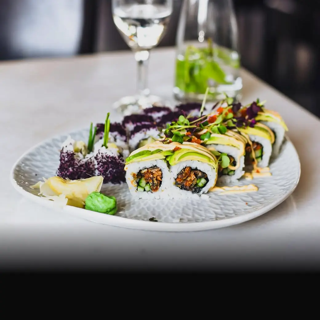 Vegetarische Sushi-Rolle mit Avocado auf einem hellen Teller